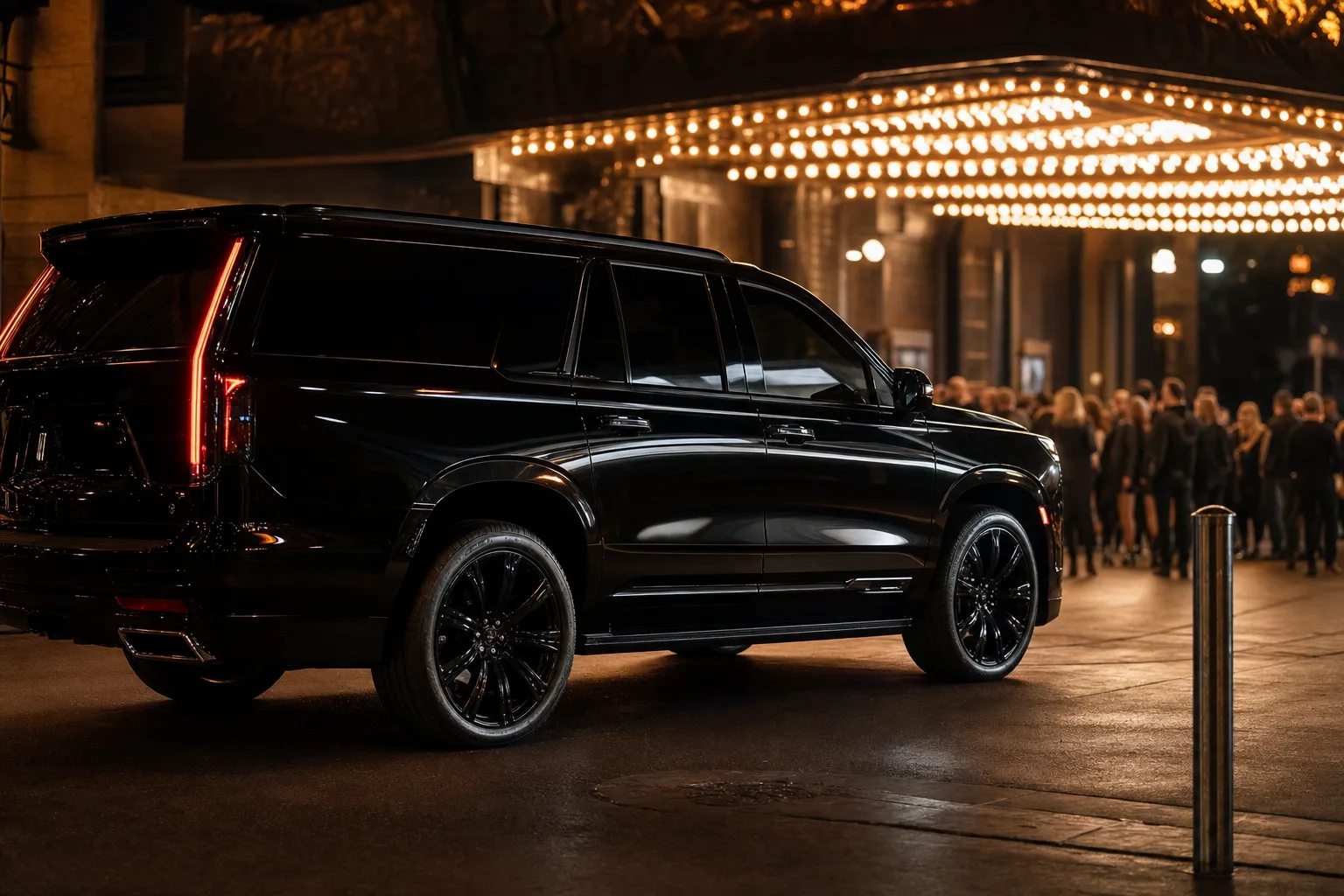 Black luxury SUV outside a concert arena at night with glowing marquee lights